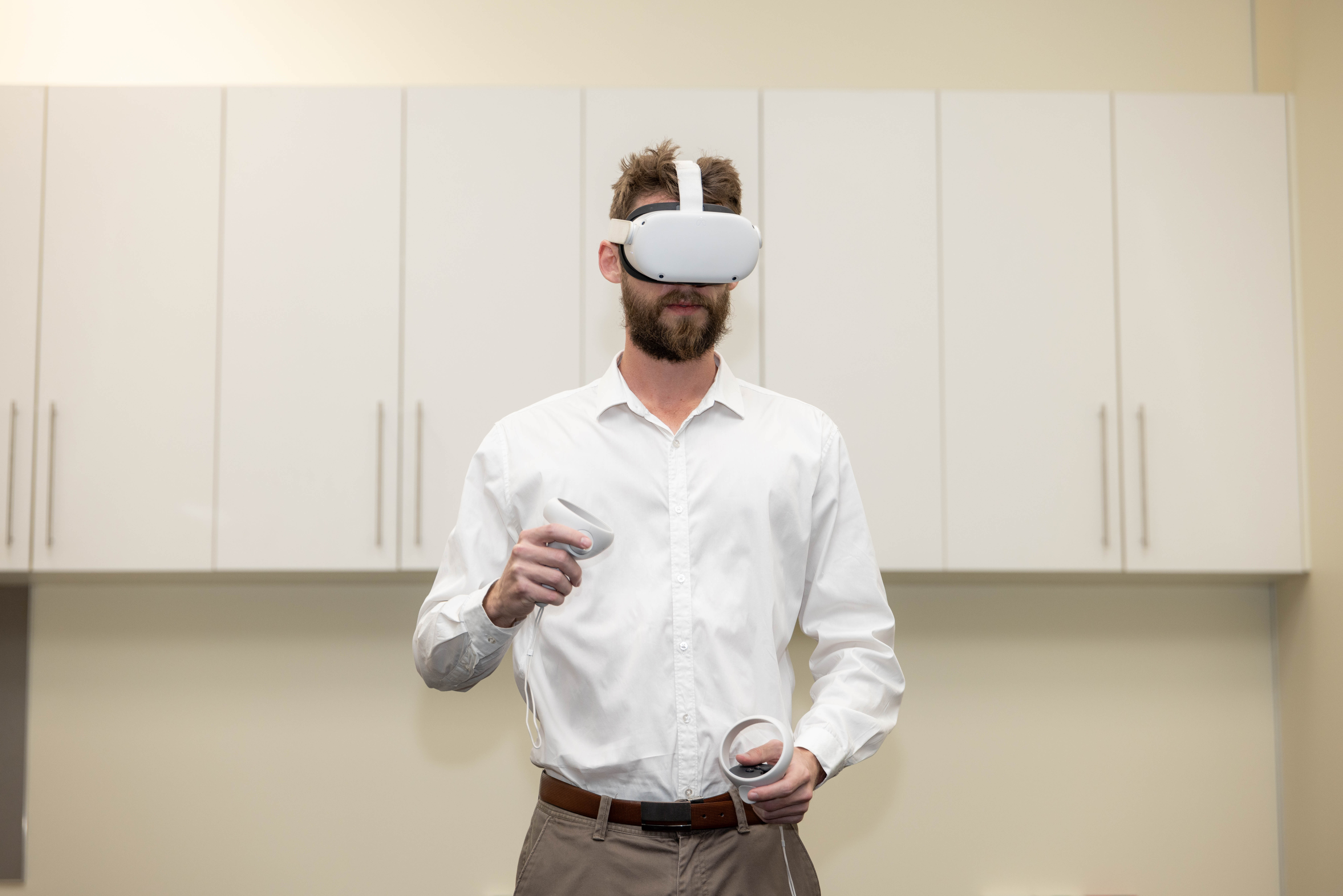 A person wearing a Meta Quest 2 VR headset and holding both controllers