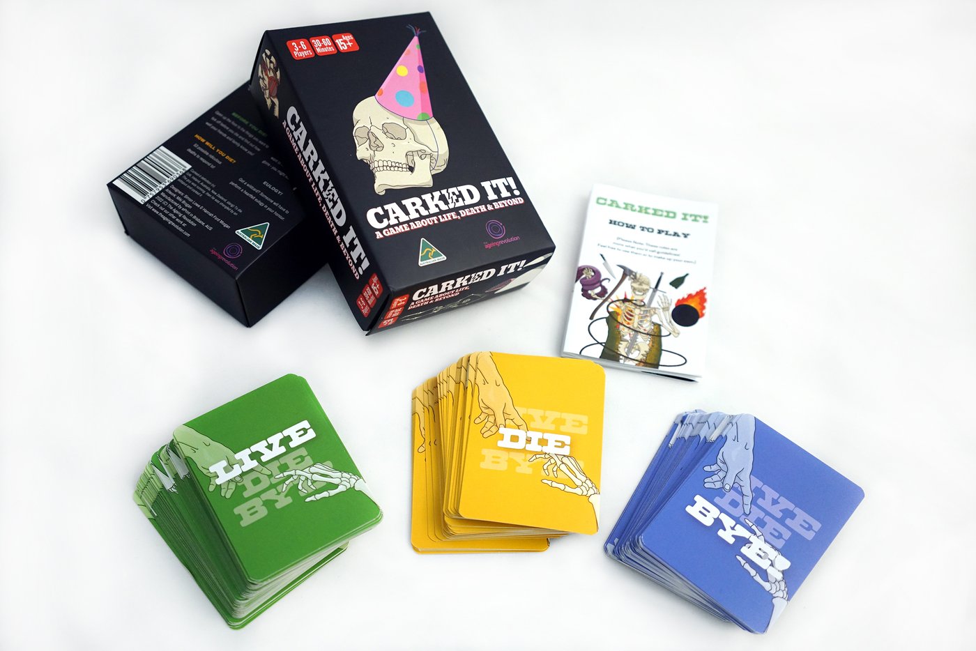 The Carked It! card game box with a party-hat skull and three decks of LIVE, DIE and BYE cards