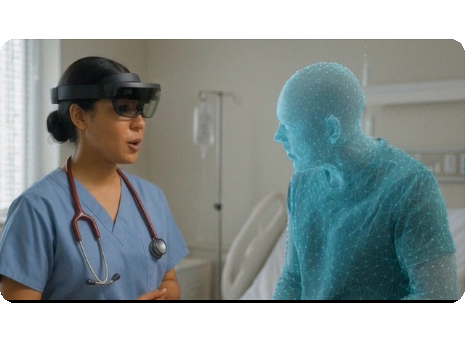 A clinician wearing a HoloLens mixed-reality headset facing a translucent holographic figure in a hospital room