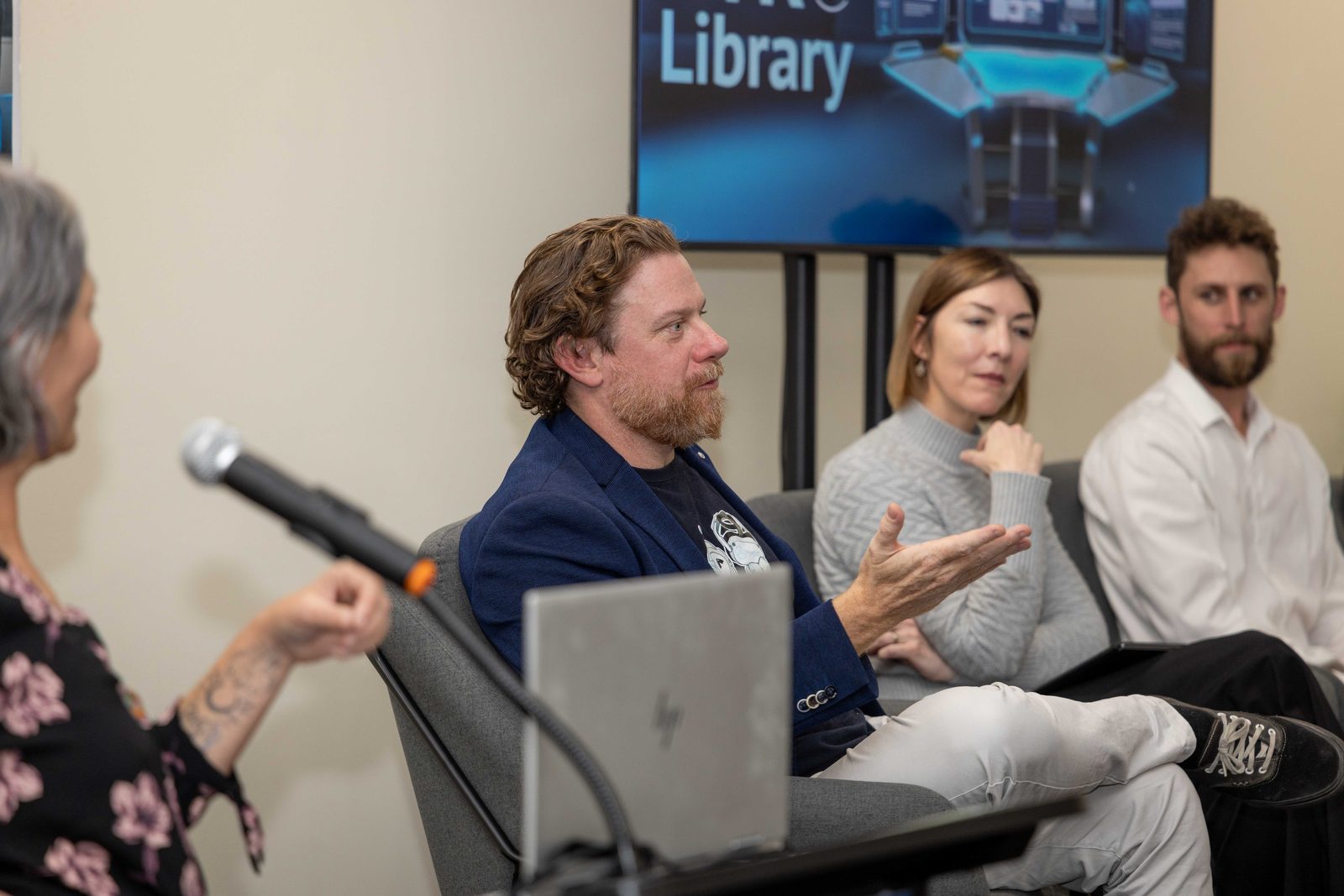 Speakers seated in a row taking part in an expert panel at a PTR VR Training Library event