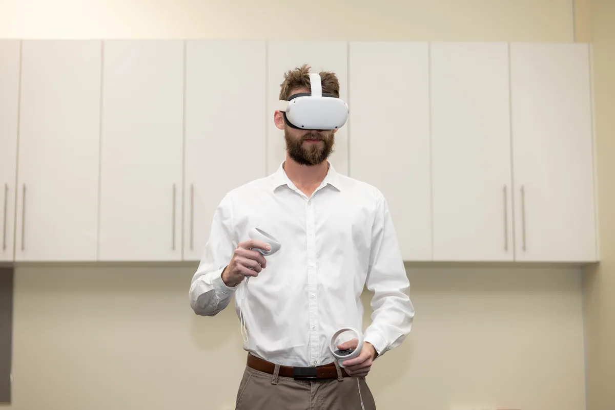 A guest in a headset holds both controllers at the PTR VR Library launch in Townsville.