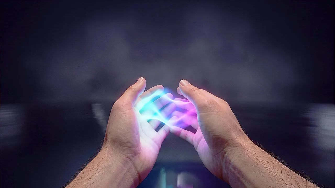 Two hands cup a small form of blue and pink light in a dark room.