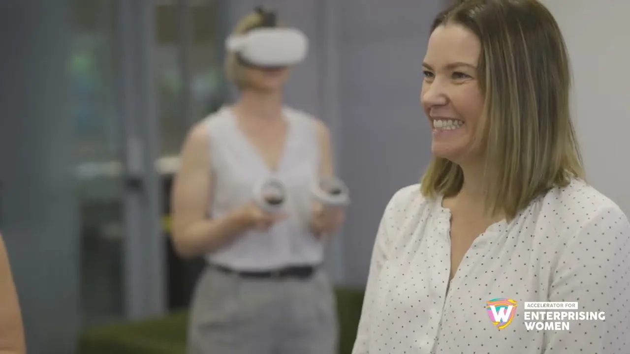Two founders in a sunlit loft office, one wearing a headset.