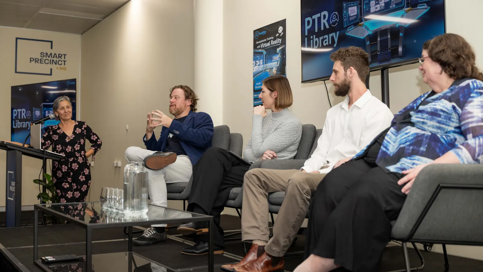 Leonie Sanderson at the lectern and Simon Lowe answering a question on the panel at the PTR Immersive Training Library launch, Smart Precinct NQ, Townsville